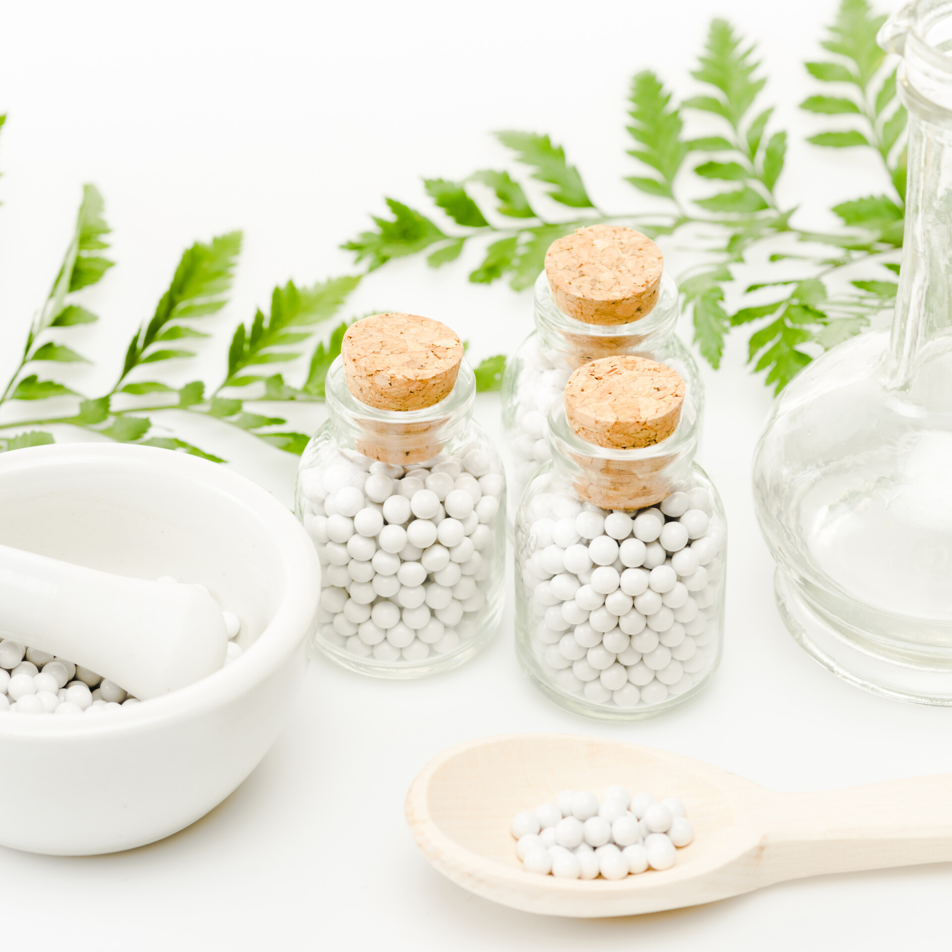 glass bottles with small round pills near mortar and pestle, wooden spoon, jar and green leaves on glass bottles with small round pills near mortar and pestle, wooden spoon, jar and green leaves on - Wholistic Healing, Naturopathic Care, About Us - IV Therapy - MedLink Health Solutions - Dr. Samantha Ramanan - Dr. Sam - Naturopathic Physician in AZ