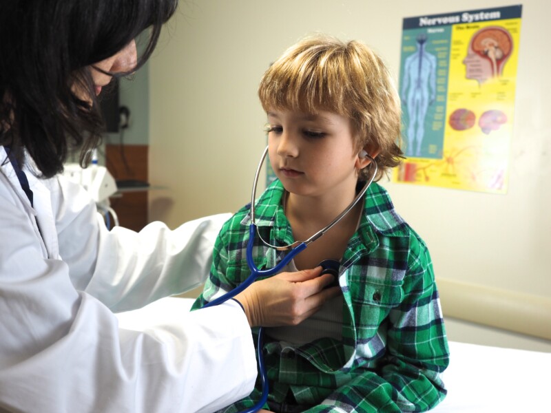 Doctor examining a child with a stethoscope at a hospital